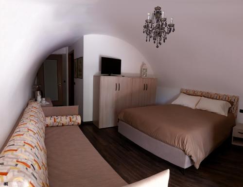 a bedroom with a bed and a chandelier at La Casa sulla Roccia in Pisogne