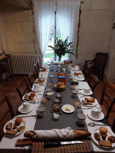 Una mesa larga con platos de comida encima. en La Bohal' Loire, en La Bohalle