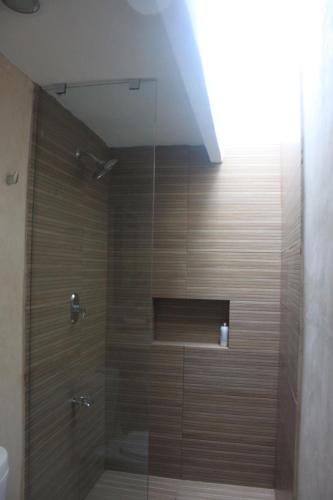 a shower with a glass door in a bathroom at Great location safe & beautiful w Beach Club in Mérida