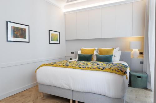 - une chambre dotée d'un grand lit avec des oreillers jaunes et bleus dans l'établissement Pick A Flat's Apartment in Saint-Germain, Bon Marché - Rue de Babylone, à Paris