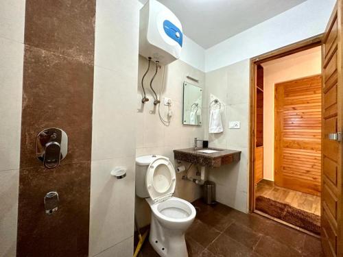 a bathroom with a toilet and a sink at Rockwood b&b in Manāli