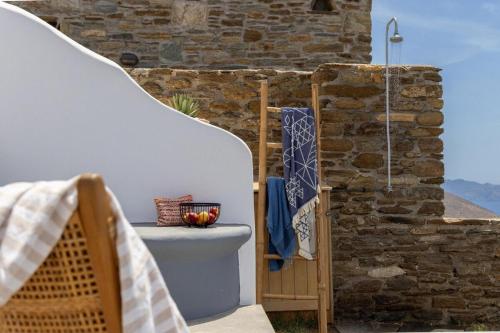 a patio with a stone wall and a bath tub at Del Sol View Arnados Tinos in Arnados