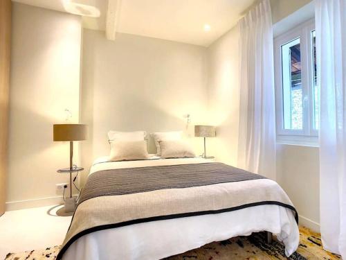 une chambre avec un grand lit avec une fenêtre dans l'établissement BEST location in Cannes! Just renovated!, à Cannes