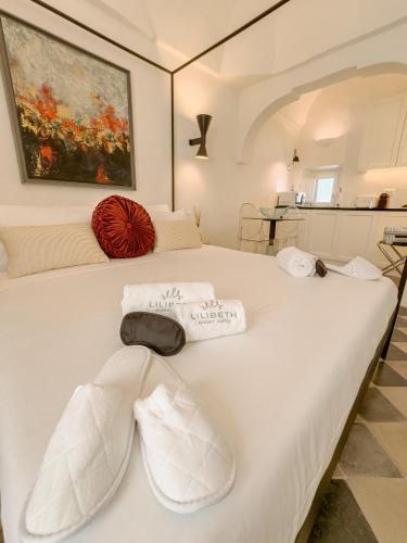 a bedroom with a white bed with towels on it at Lilibeth Luxury Suites - Ostuni in Ostuni