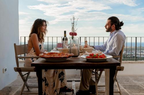 een man en vrouw aan een tafel met eten bij Lilibeth Luxury Suites - Ostuni in Ostuni