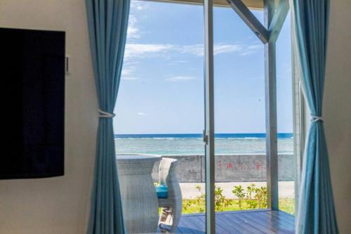 a room with a view of the ocean from a window at 石垣島一棟貸し 潮 in Ishigaki Island