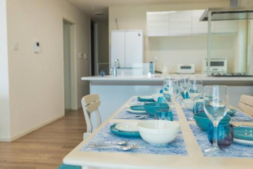 a table with glasses and plates on it in a kitchen at 石垣島一棟貸し 潮 in Ishigaki Island