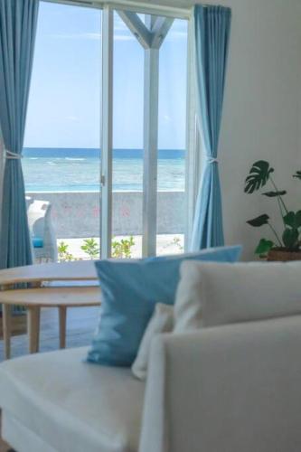 a living room with a couch and a view of the ocean at 石垣島一棟貸し 潮 in Ishigaki Island