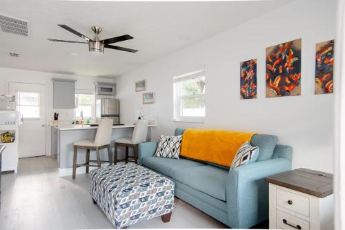 a living room with a blue couch and a kitchen at Charming 1-bedroom Oasis In The Heart Of Downtown in New Port Richey
