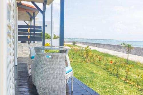 a porch with chairs and a table and a view of the ocean at 石垣島一棟貸し 潮 in Ishigaki Island