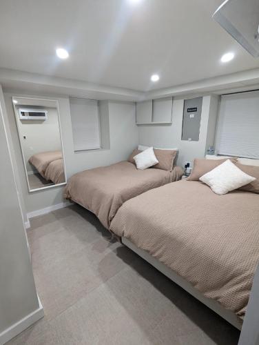 a bedroom with two beds and a mirror at Luxury Apt in Passaic