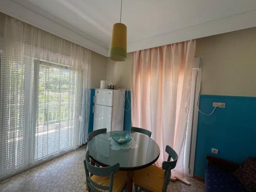 Un comedor con una mesa y un refrigerador. en Nectarios seaside apartment., en Palaión Tsiflíkion