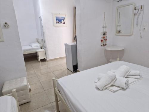 a white room with a bed with towels on it at Katerina Yalos in Ios Chora