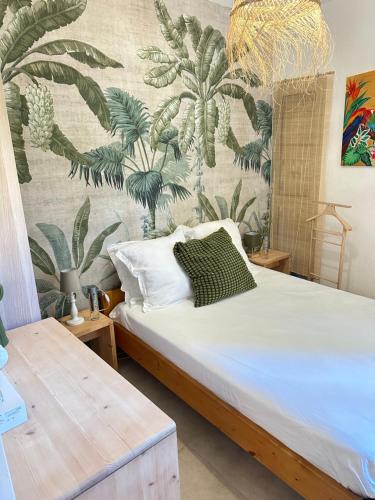 une chambre avec un lit avec un papier peint tropical dans l'établissement Appartement Sea Shell, à Cavalaire-sur-Mer
