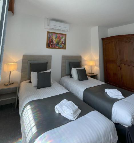 a bedroom with two beds with towels on them at The Originals Boutique, Hôtel Clos Sainte Marie, Nevers in Nevers