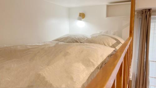 - un lit avec un cadre en bois dans une chambre dans l'établissement Charme Cosy au Cœur de Paris, à Paris