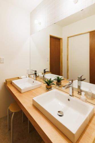 a bathroom with two sinks and a large mirror at shimagumi house 海のそばの小さな貸切り宿 in Kisarazu