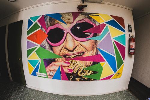 a large painting of a woman with sunglasses on a wall at hotel velero cavancha in Iquique