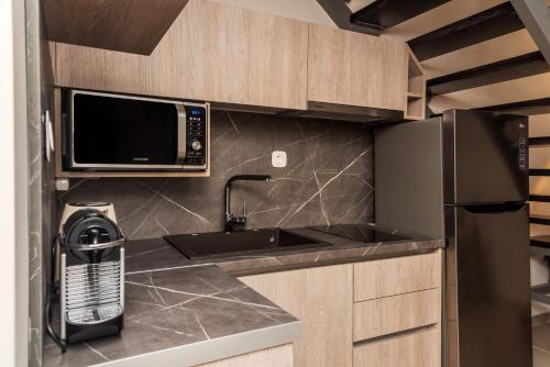 a kitchen with a sink and a microwave at Corfu Mylos in Ágios Nikólaos
