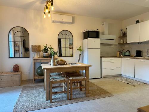 une cuisine avec une table et un réfrigérateur blanc dans l'établissement Appartement Sea Shell, à Cavalaire-sur-Mer