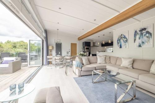 a living room with a couch and a table at Luxury Lodge with Hot Tub in Windsor Marina - By Tempstay in Windsor