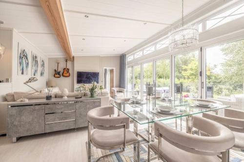 a dining room with a glass table and chairs at Luxury Lodge with Hot Tub in Windsor Marina - By Tempstay in Windsor