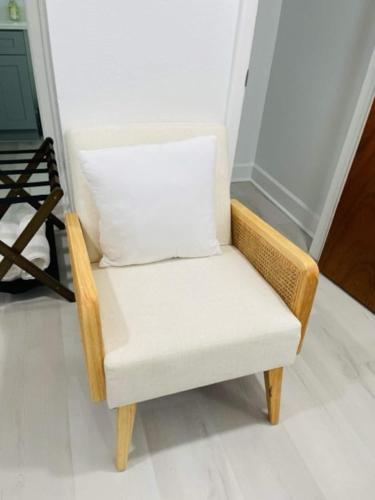 a wicker chair with a white pillow on it at Walk Everywhere! 1-bedroom Gem In Downtown Hub in New Port Richey