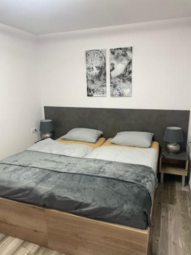 a bedroom with two beds and two pictures on the wall at Rado Apartments in Svit