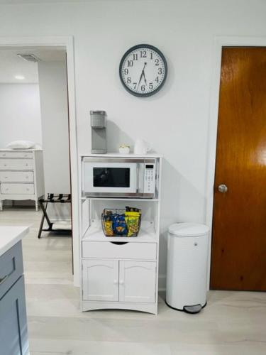 a kitchen with a microwave and a clock on the wall at Charming 1-bedroom Oasis In The Heart Of Downtown in New Port Richey