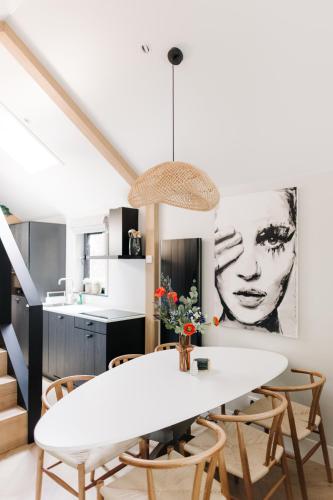 a kitchen and dining room with a white table and chairs at Tiny House Veluwse Vlucht in Stroe