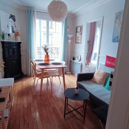 un salon avec une table et un canapé dans l'établissement Authentic suites parisien -Paris historique, à Saint-Ouen