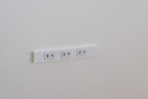 a white electrical outlet on a white wall at shimagumi house 海のそばの小さな貸切り宿 in Kisarazu