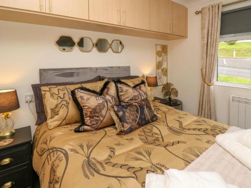 Un dormitorio con una cama con almohadas encima. en The Dragonfly, en New Quay