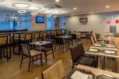 a restaurant with tables and chairs and a bar at ibis Sao Jose dos Campos Colinas in São José dos Campos