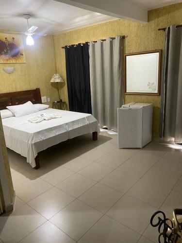 a bedroom with a bed and a white tiled floor at Hotel Olivier in Três Rios