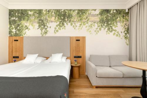 a bedroom with a bed and a couch at Chaber Apartamenty in Swornegacie 