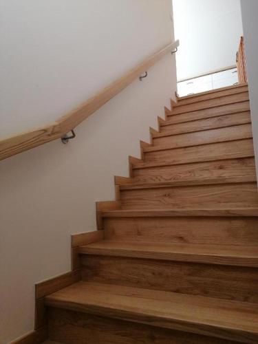 a staircase with wooden steps in a house at Agroturystyka Nocleg na Górce in Łajsy