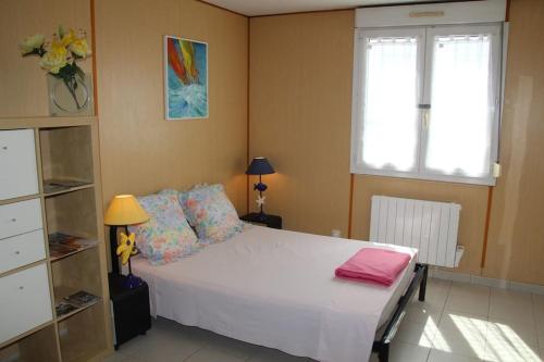 une chambre avec un lit blanc et une fenêtre dans l'établissement Grand Studio à La Rochelle Près de Vieux Port, à La Rochelle