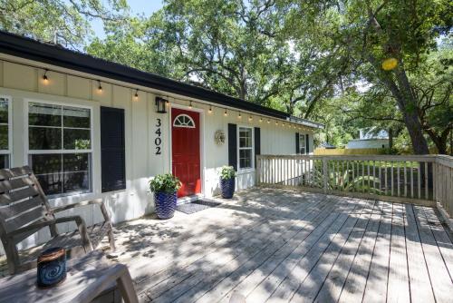 een huis met een terras met een rode deur bij Red Rooster Cottage in Freeport