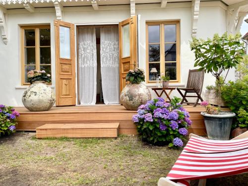a porch of a house with three large vases at Weißt Du noch - Gästehäuser & Suiten in Kühlungsborn