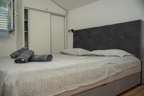 a bed with a black headboard in a bedroom at Apartman Jadrija Šibenik 2 in Šibenik