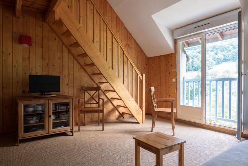 a living room with a staircase and a television at Garden & City Bagnères-de-Bigorre - Domaine de Ramonjuan in Lesponne