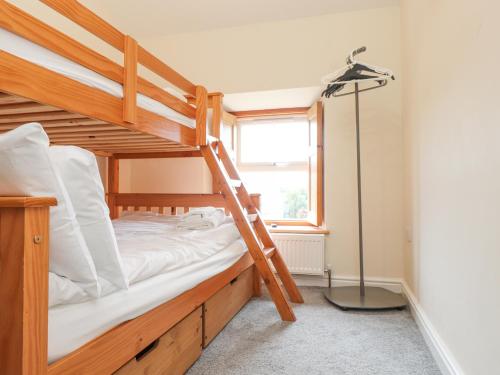 un letto a castello con una scala in una stanza di The Cottage a Pwllheli