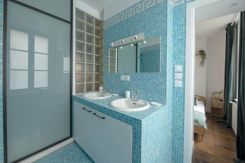 une salle de bain avec un lavabo et un miroir dans l'établissement La Place Saint-Michel, à Rennes