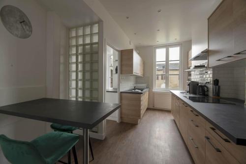 une cuisine avec une table et des chaises dans une pièce dans l'établissement La Place Saint-Michel, à Rennes
