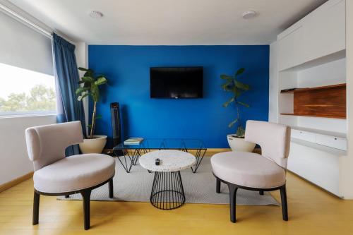 a living room with two chairs and a blue wall at Amazing 3BR near Parque México in Condesa in Mexico City