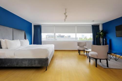 a bedroom with a large bed and a blue wall at Amazing 3BR near Parque México in Condesa in Mexico City