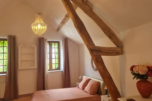 a bedroom with a bed and a vase with flowers at Belle maison, 2 chambres dans corps de ferme - logement Raphaël in Villiers-sous-Grez