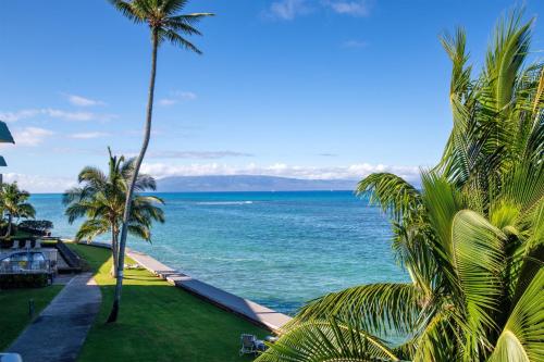 a view of the ocean from a resort with palm trees at Amazing Sunsets Oceanfront Views - indigomaui - in Kahana