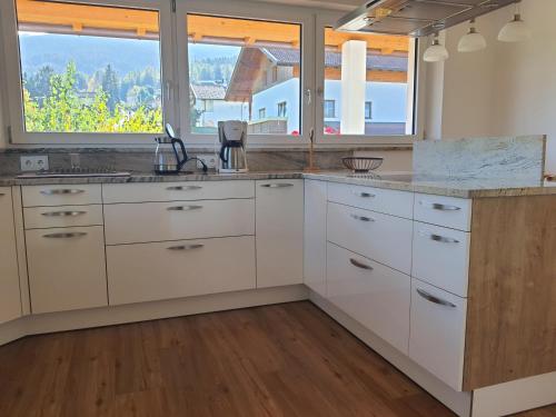 a kitchen with white cabinets and a large window at Hotel Garni Schieferle in Innsbruck